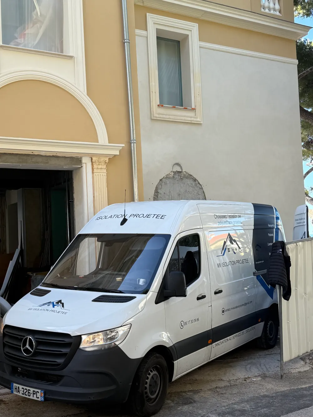 Utilitaire marqué MV Isolation Projetée devant une façade